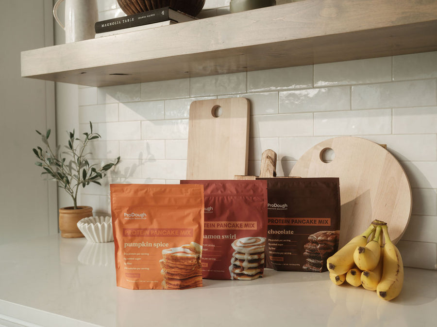 ProDough Protein Pancake and Waffle Mix lineup with Magnolia Table cookbook